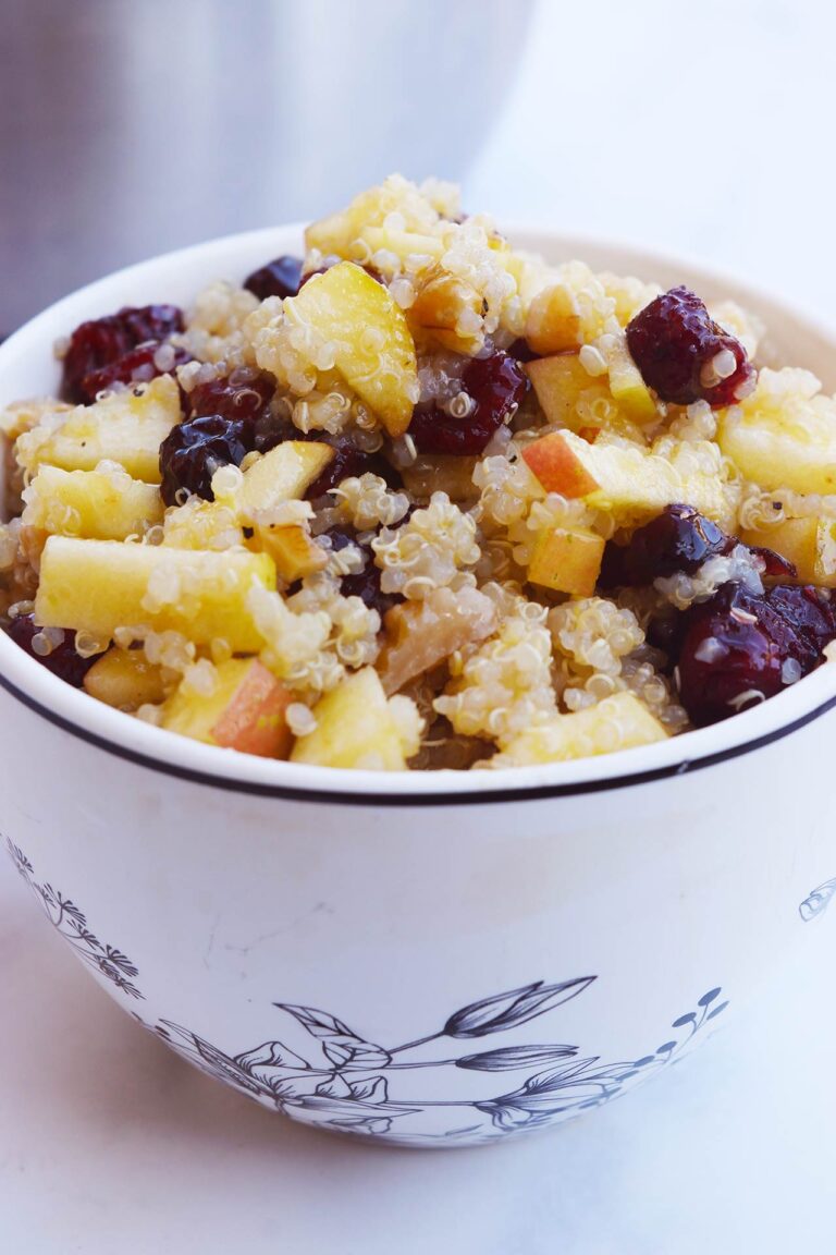 Front view of a decorative mug filled with Cranberry Apple Quinoa Salad.