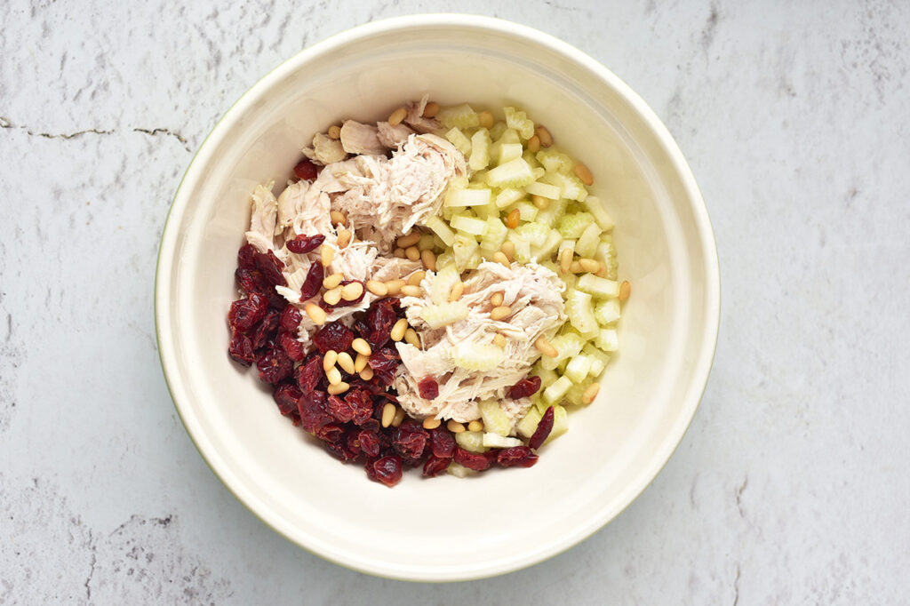 Ingredients for a Cranberry Chicken Salad in a mixing bowl.