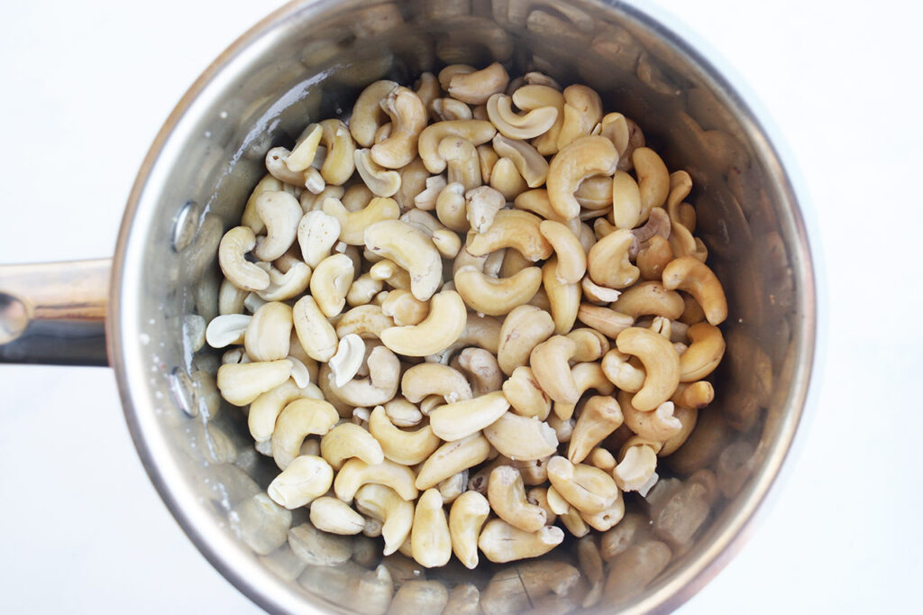 Boiled and drained cashews in a pot.