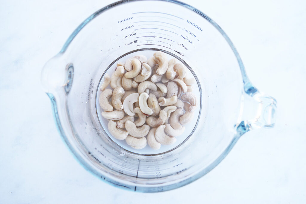 Cashews in a cup with water.