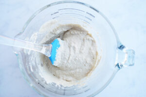Cashew cream in a cup with a spatula.