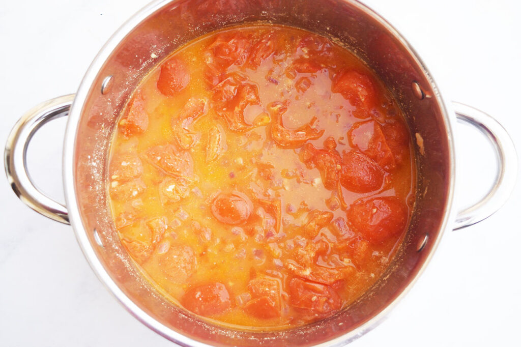 Cooked, unblended tomato soup in a soup pot.