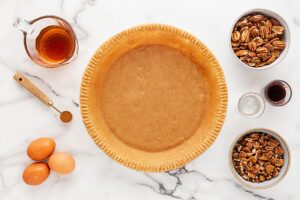 Ingredients for pecan pie on a white marble surface.