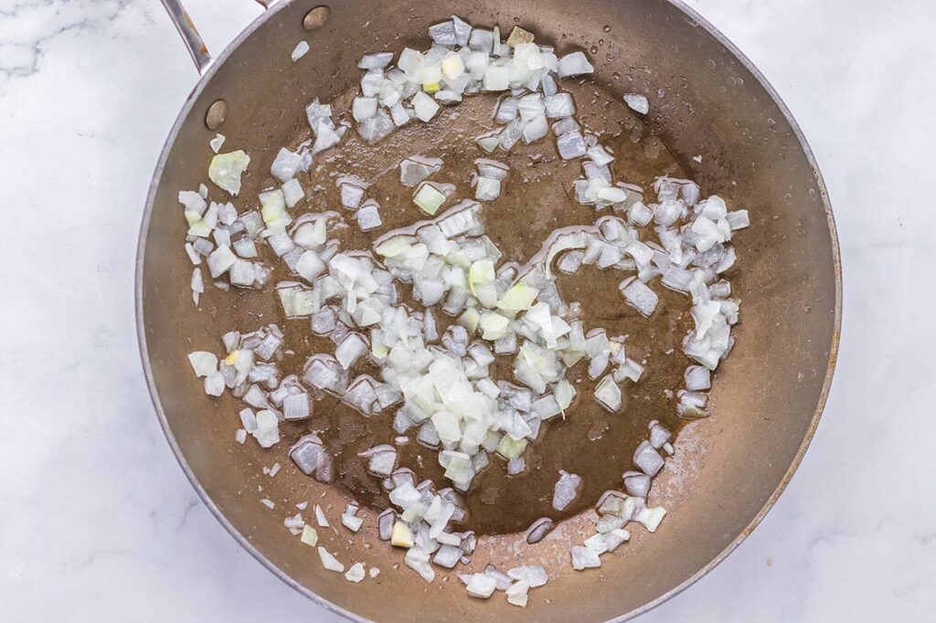 Onions sautéing in a skillet.