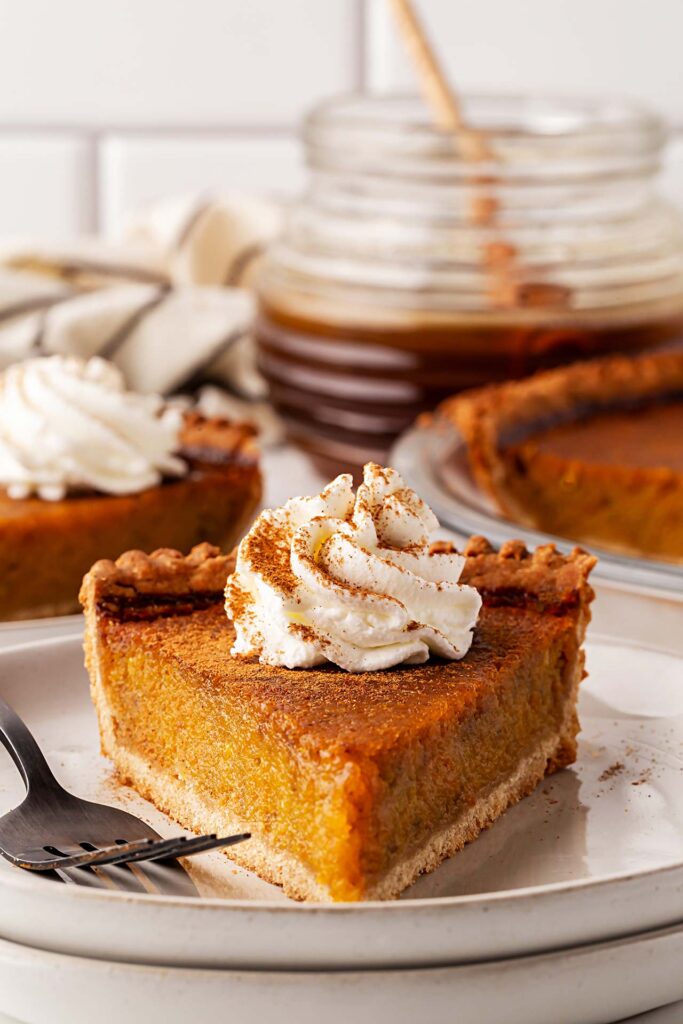 Front view of slice of pumpkin pie on a plate.