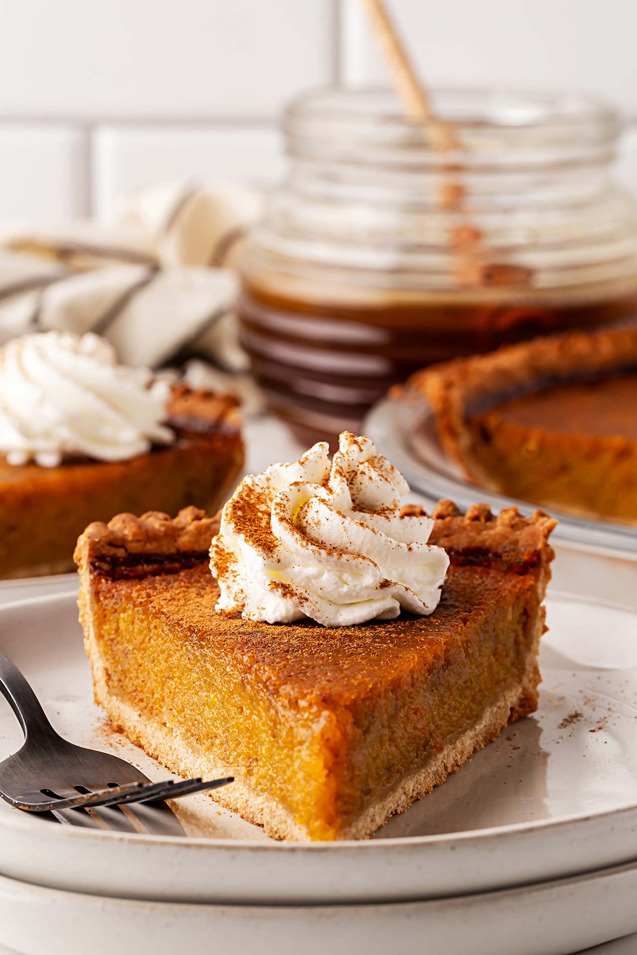Front view of slice of pumpkin pie on a plate.