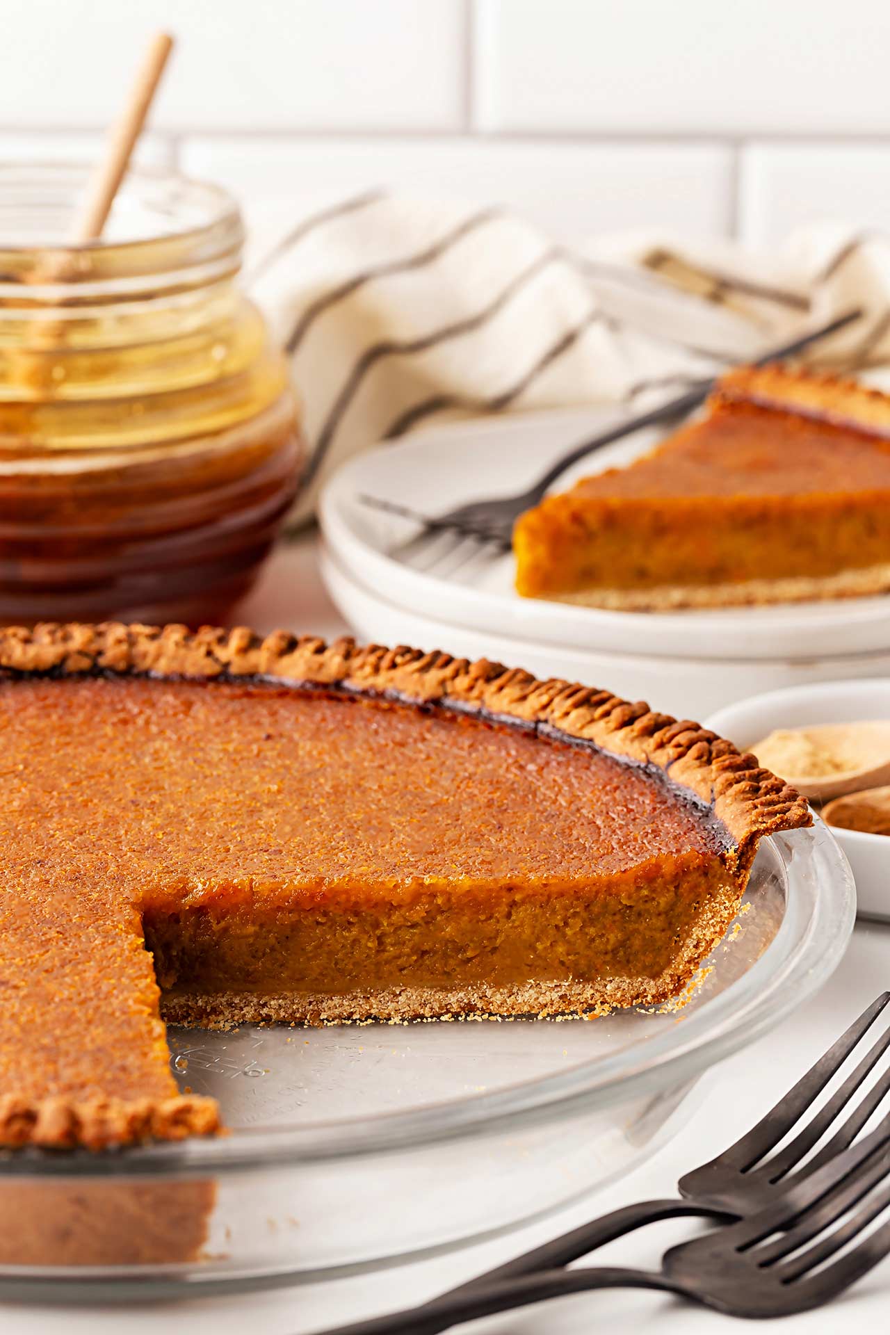 Side view of a whole Pumpkin Pie with a slice removed.