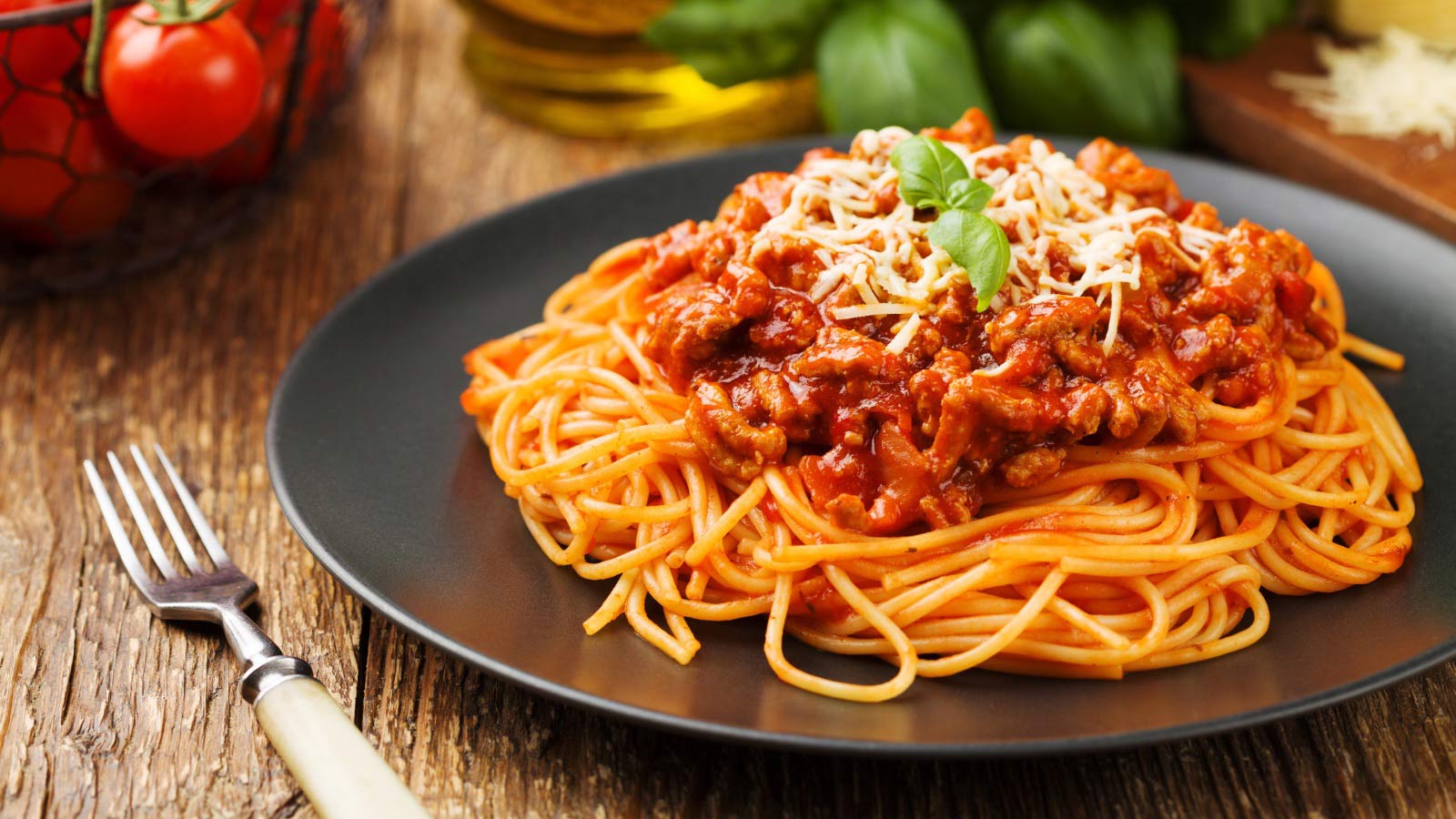 Delicious spaghetti served on a black plate.