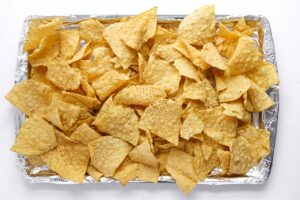 Chips spread over a foil-lined baking sheet.
