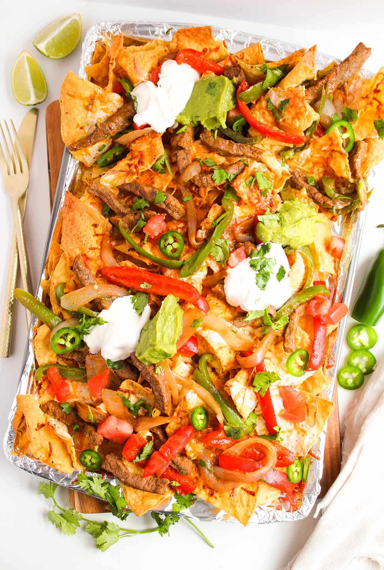 Steak Nachos with all the toppings on a sheet pan.