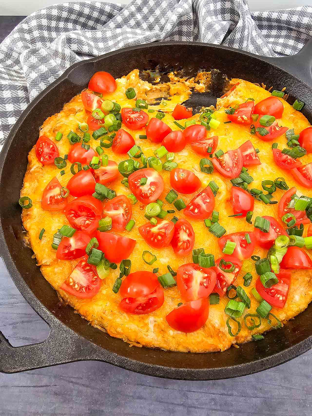 Front view of an iron skillet filled with Texas Trash Dip.
