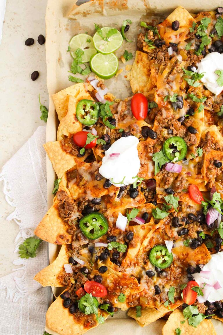 Closeup overhead focus of garnished Beef Enchilada Nachos.