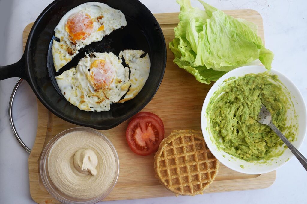 Ingredients for Breakfast Mediterranean Sandwiches on a cutting board.