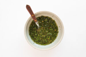 Chimichurri sauce ingredients combined together in a mixing bowl.