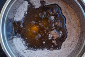 Chocolate bread wet and dry ingredients in a mixing bowl.