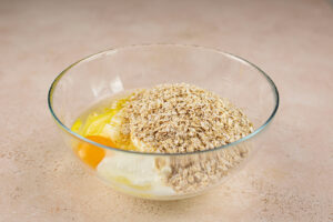 Oat bread ingredients in a glass mixing bowl.