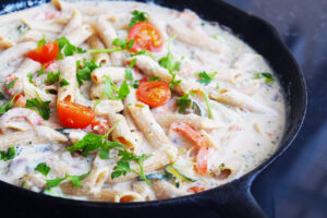 Front view of a skillet filled with Pasta Primavera.