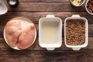 Assembly line setup for breading chicken breasts.