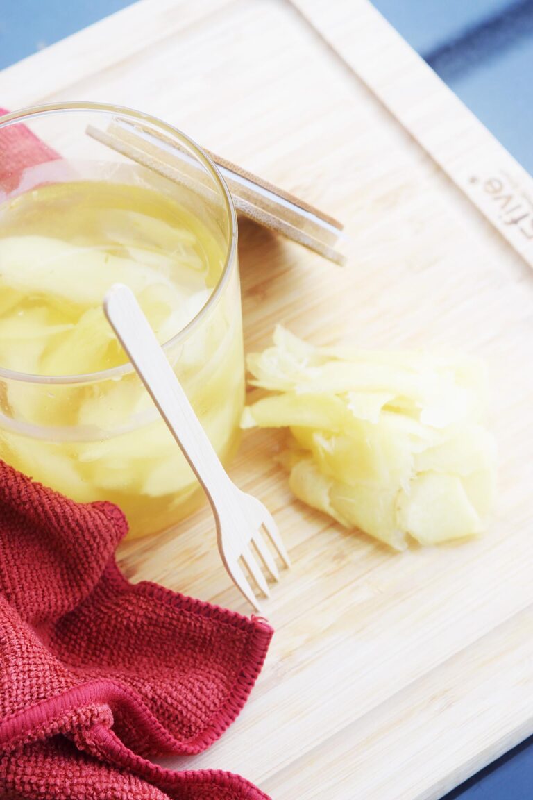 Overhead focus. Pickled ginger in a jar and on a cutting board the jar is sitting on.