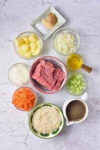 Turkey Meatball Soup Recipe ingredients in individual bowls on a white surface.