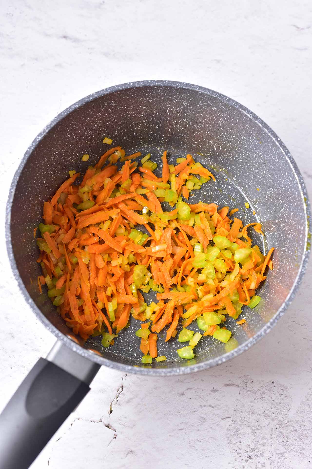 Chopped and grated vegetables in a pot.