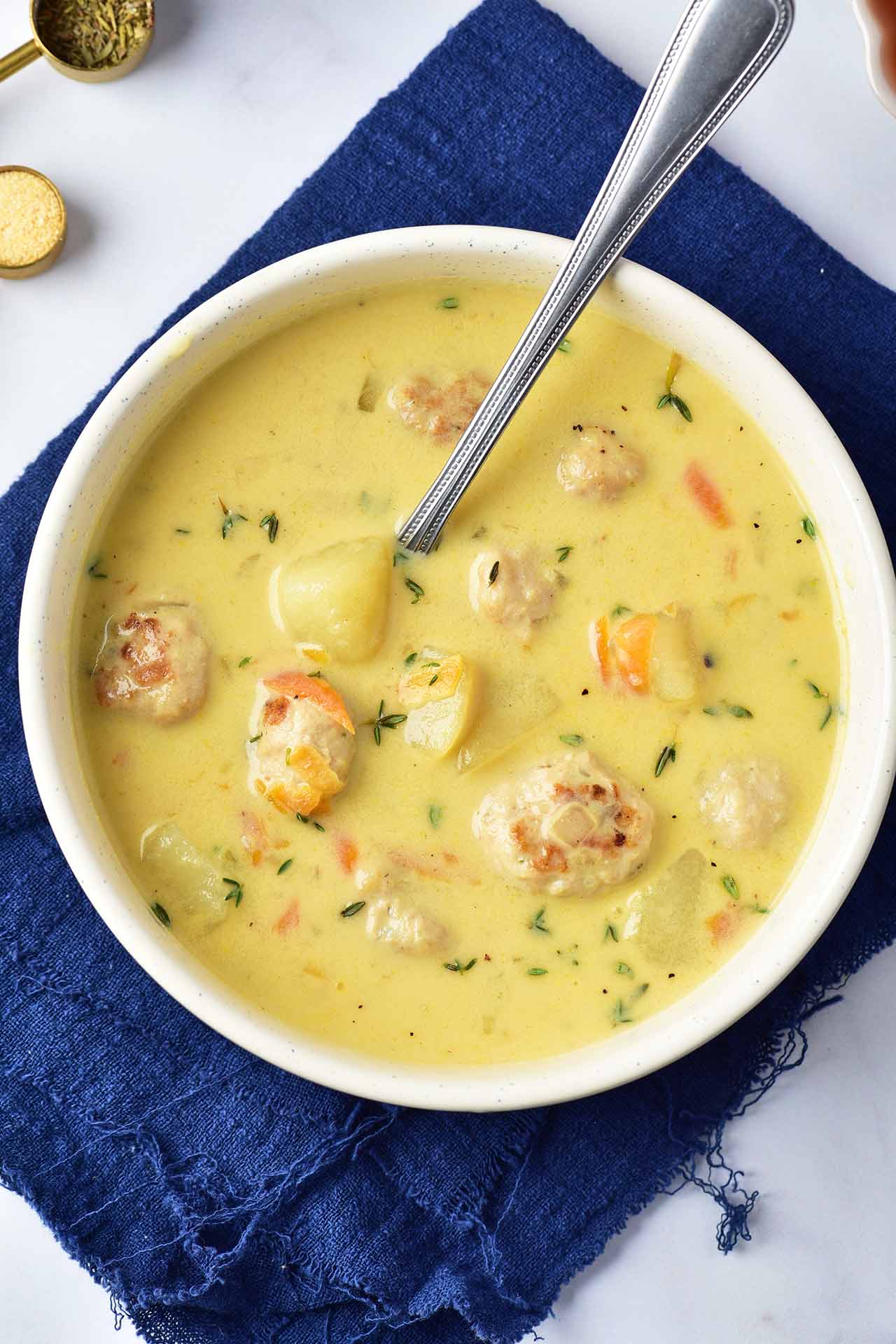 Overhead view of a white bowl full of Turkey Meatball Soup.