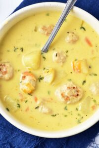 Closeup overhead view of a white bowl filled with Turkey Meatball Soup.