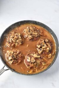 Letting the Salisbury steaks cool before serving.