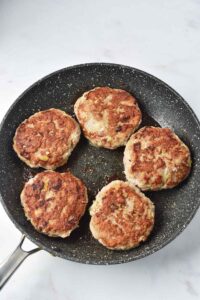 Cooked Turkey Salisbury Steak patties in a skillet.