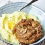 Front view of a Turkey Salisbury Steak over mashed potatoes.