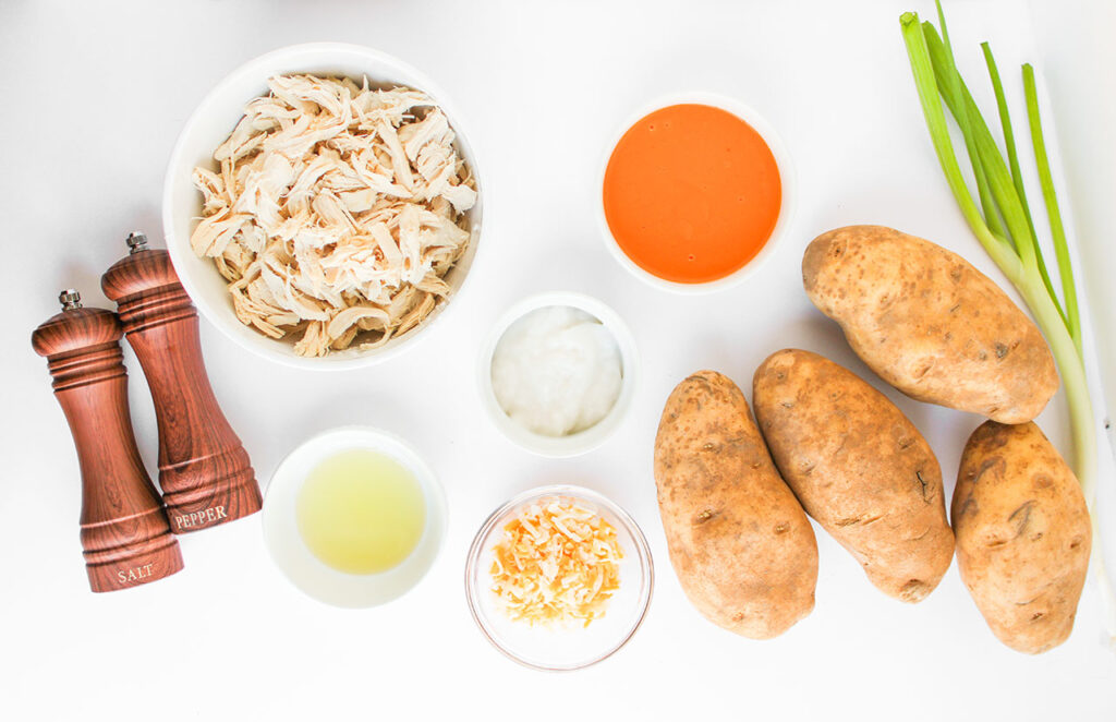 Buffalo Chicken Stuffed Baked Potato recipe ingredients on a white background. Overhead focus.