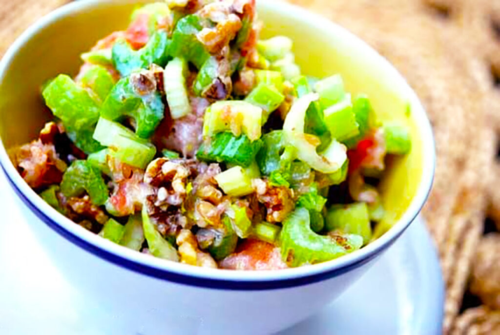 Horizontal orientation. White bowl filled with Celery Salad.