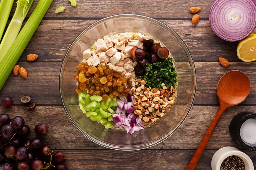 curry chicken salad components in a mixing bowl. Overhead focus.