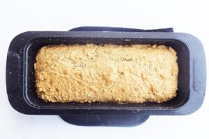 Baked bread cooling in a loaf pan. Overhead view.
