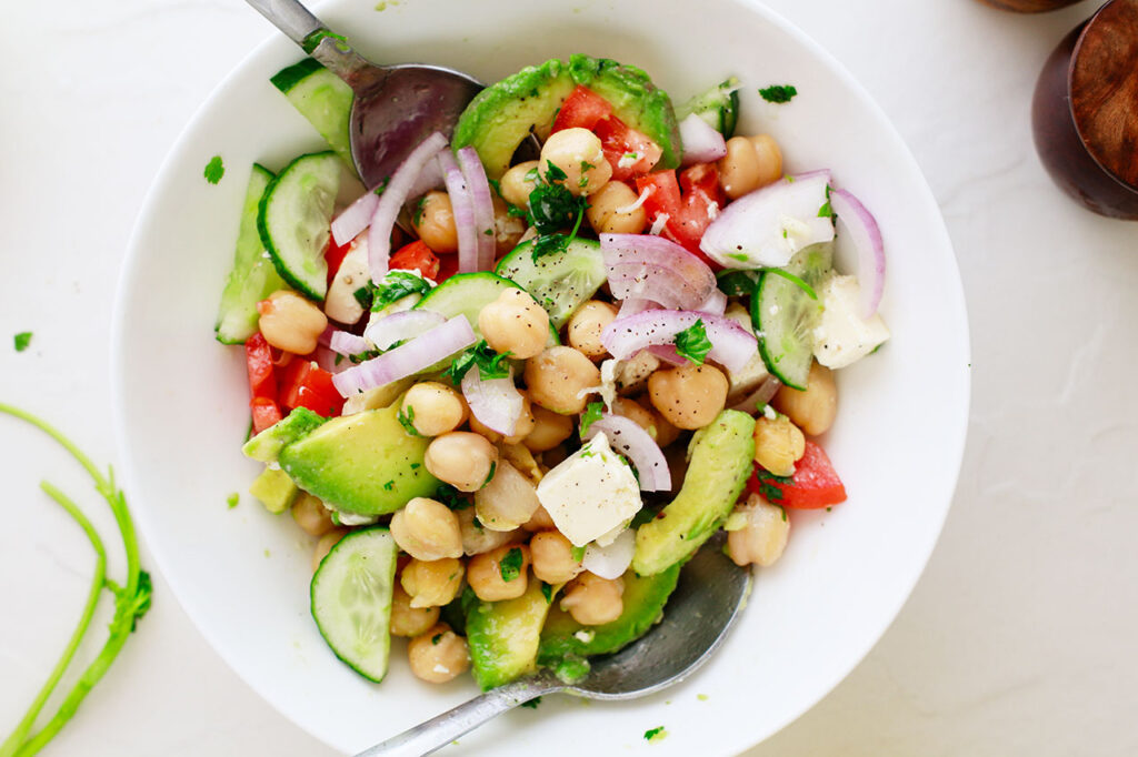 The finished Mediterranean Chickpea Salad in a white mixing bowl. Overhead focus.