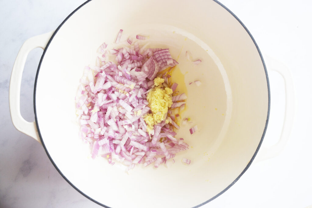 Onions and ginger sautéing in oil in a dutch oven.
