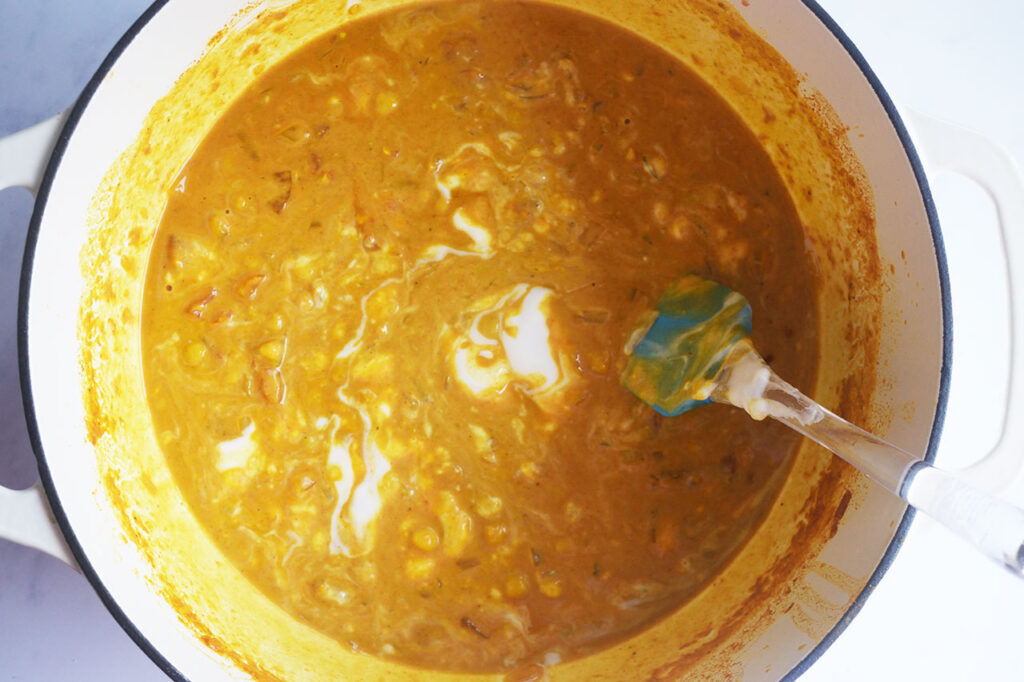 Stirring yogurt into Moroccan Chickpea Stew for a creamy version of the recipe.