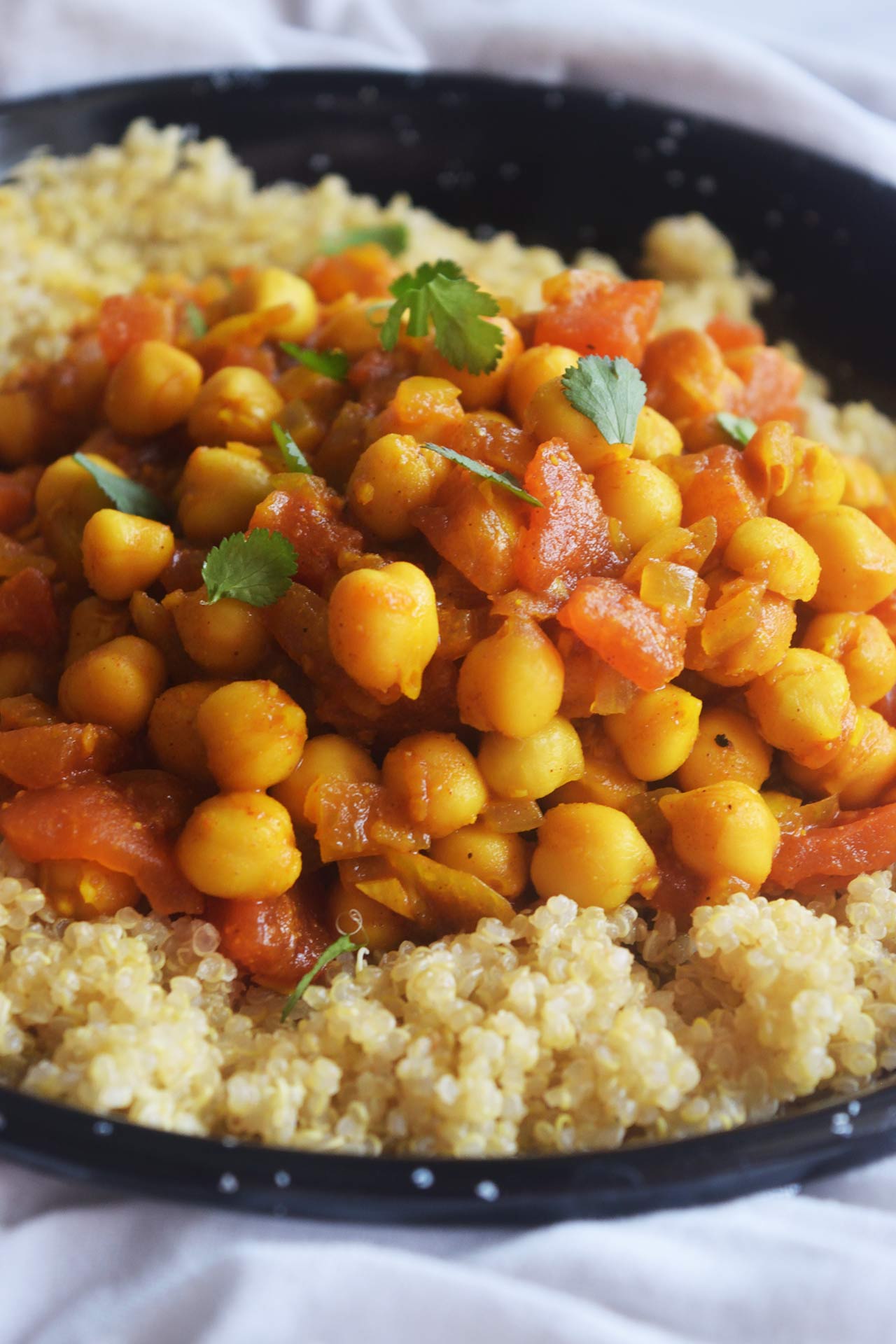 Front focus. Moroccan Chickpea Stew served over a bed of quinoa.