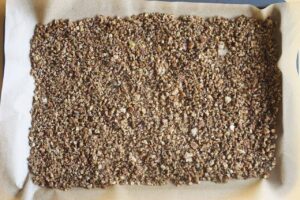 Pangrattato spread over the parchment-lined baking sheet.