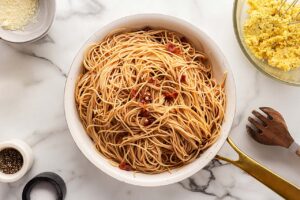 Pasta tossed in a skillet with the bacon and garlic.
