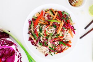 Overhead view of a white bowl filled with Spring Roll Salad.