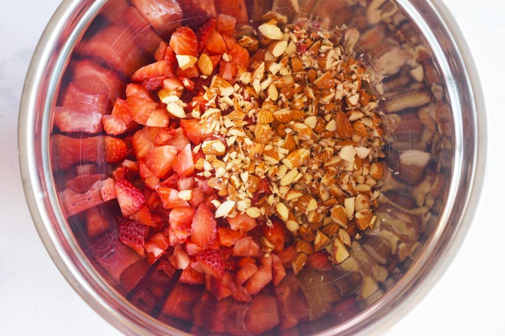 Chopped strawberries and chopped almonds in a mixing bowl.
