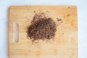 Shaved or grated chocolate on a wood cutting board.