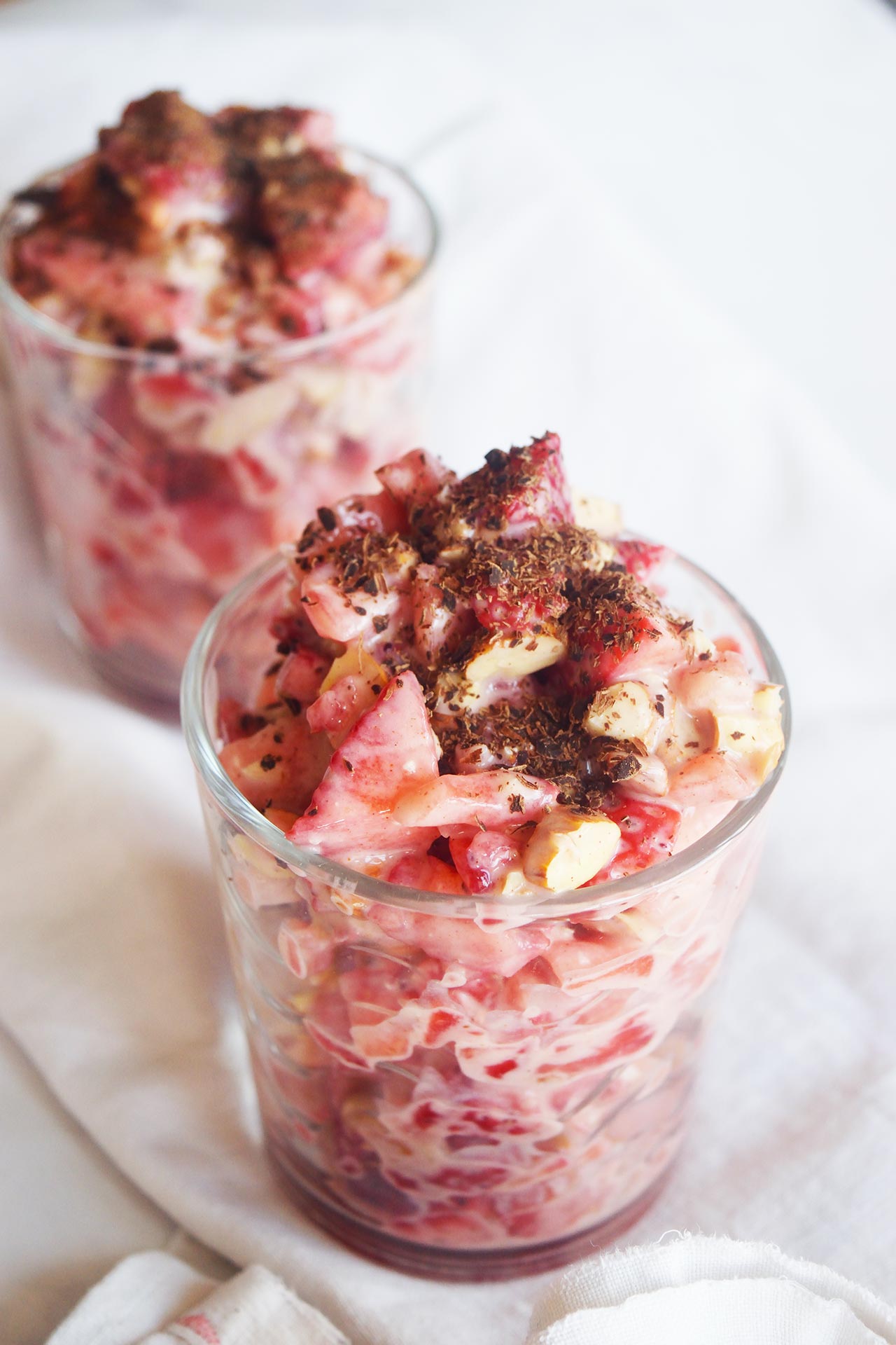 Two clear, glass cups filled with Strawberry Salad and garnished with shaved chocolate.
