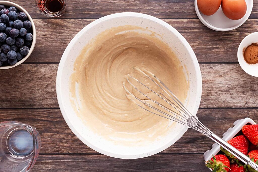 Whisked flour and milk in a mixing bowl.