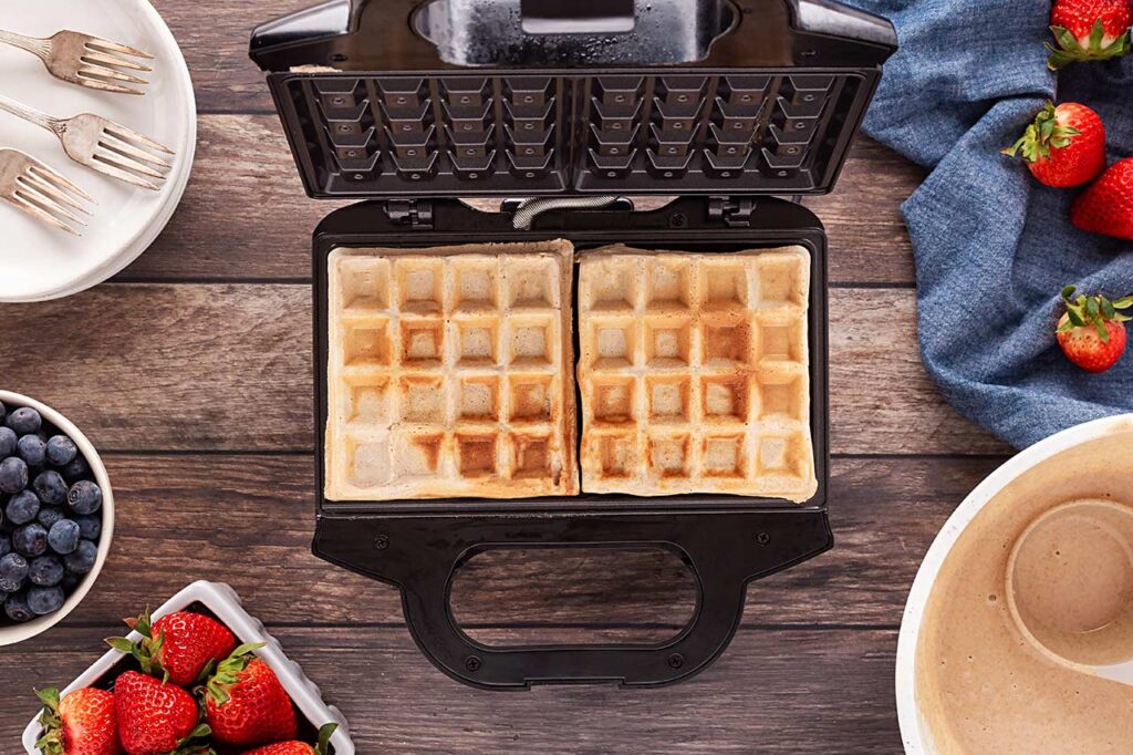 Cooked waffles on a waffle maker.