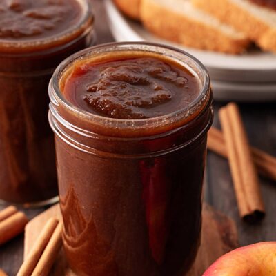 Two open jars filled with apple butter.