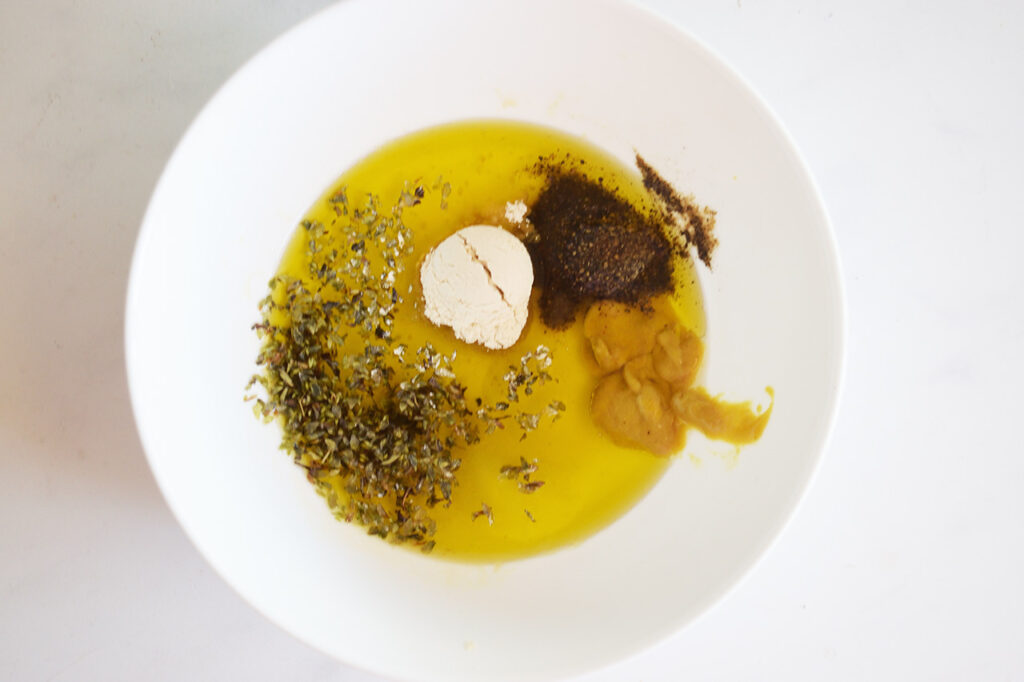 Dressing ingredients in a white bowl, unmixed.