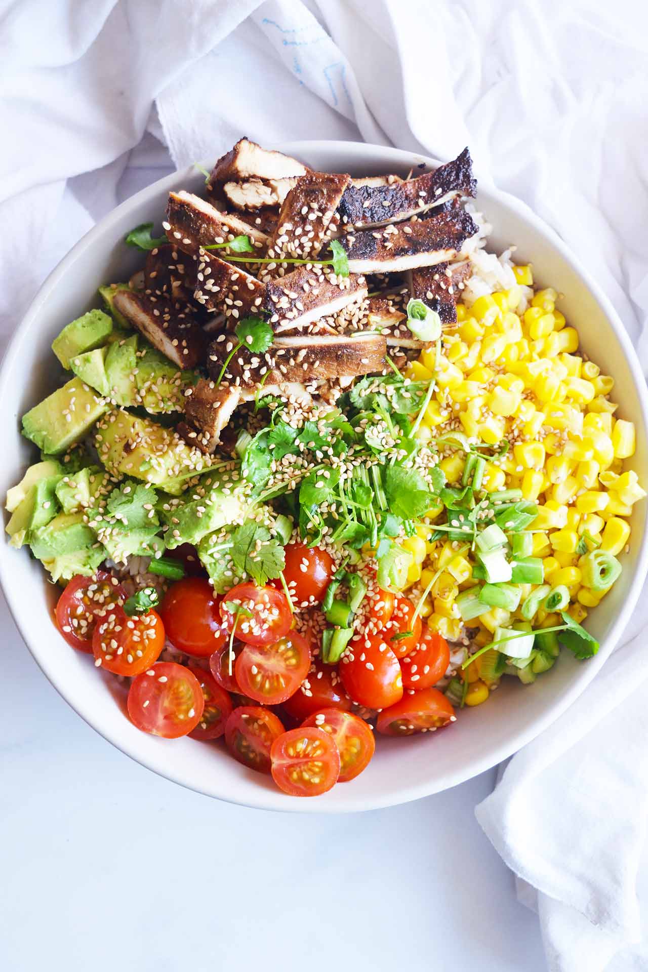 Overhead focus. Chicken Poke Bowl in a white bowl.