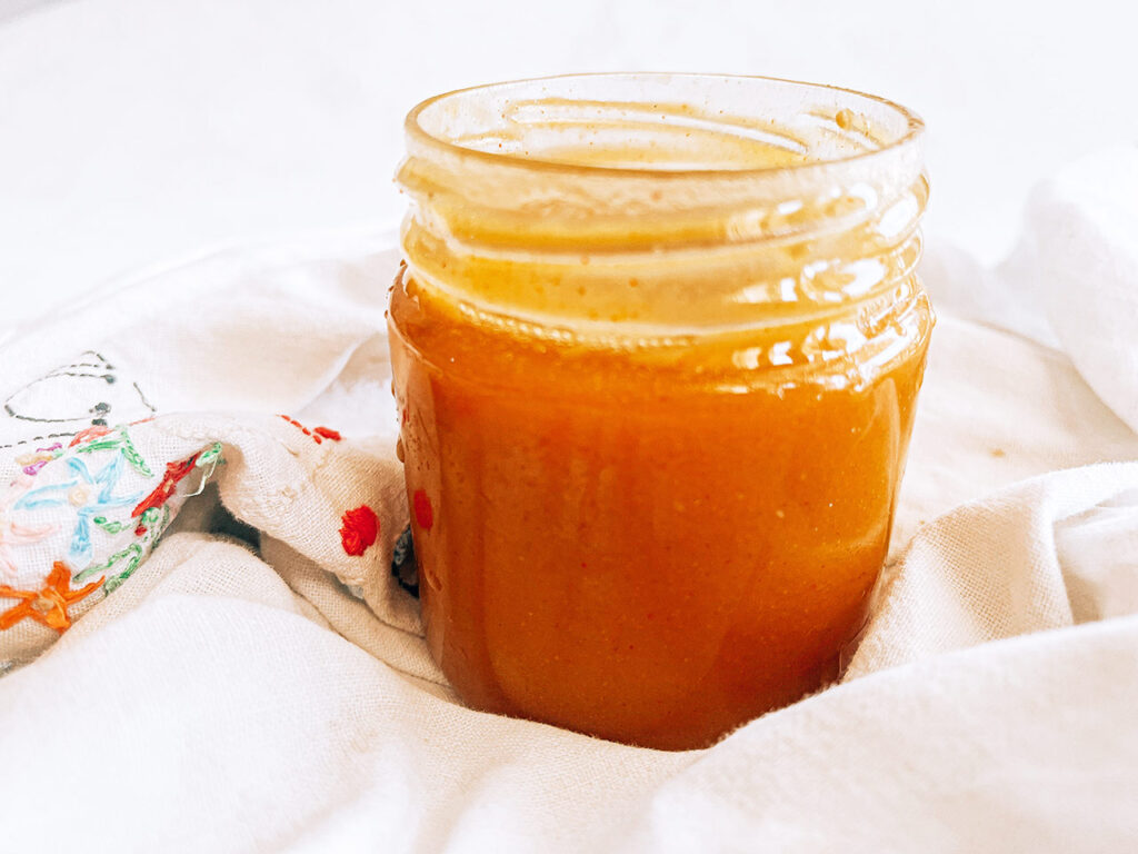 Front view of an open container of honey mustard dressing.